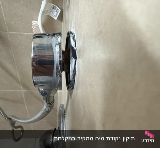 חלקי אינסטלציה עם צינור מתכת על קיר קרמיקה